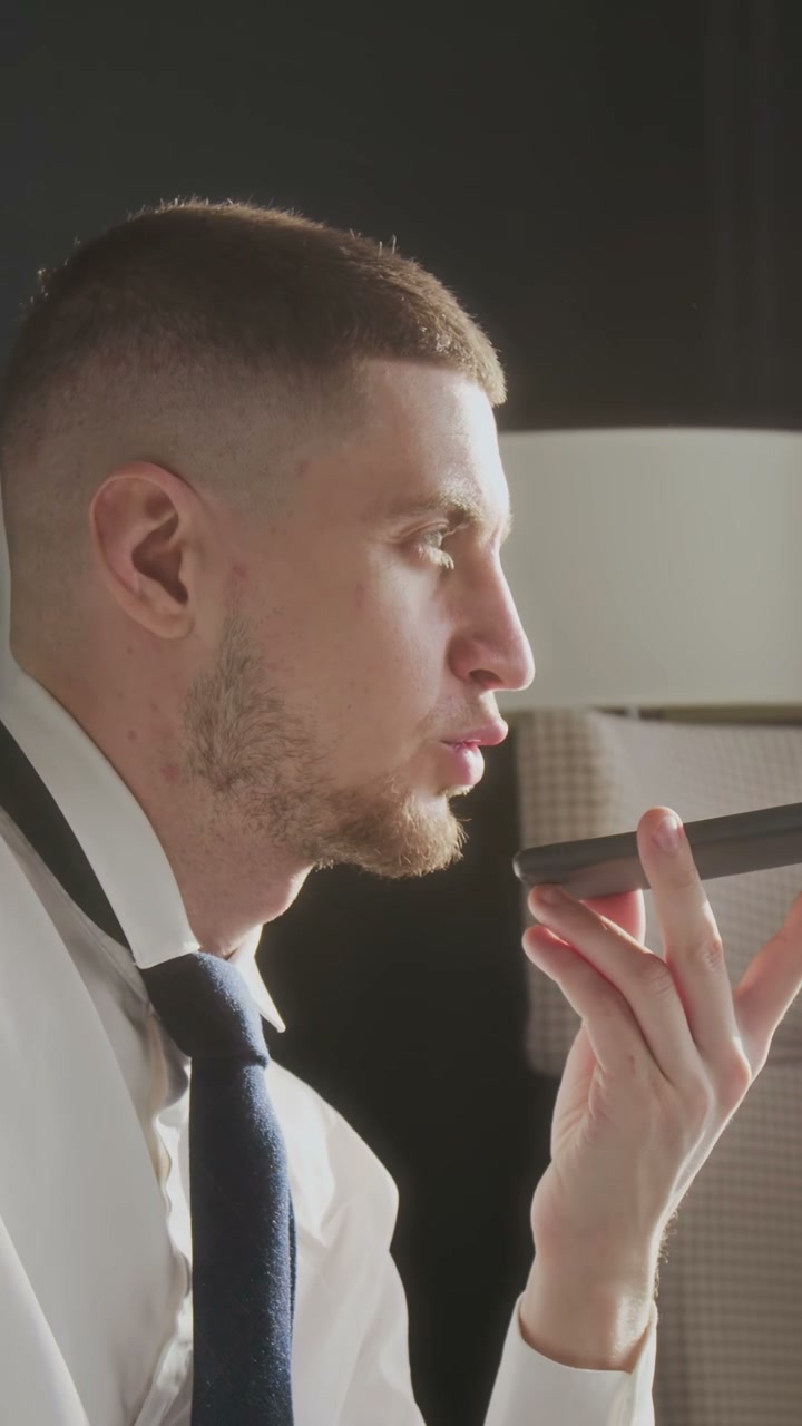 Businessman Speaking on Speakerphone in Hotel Room