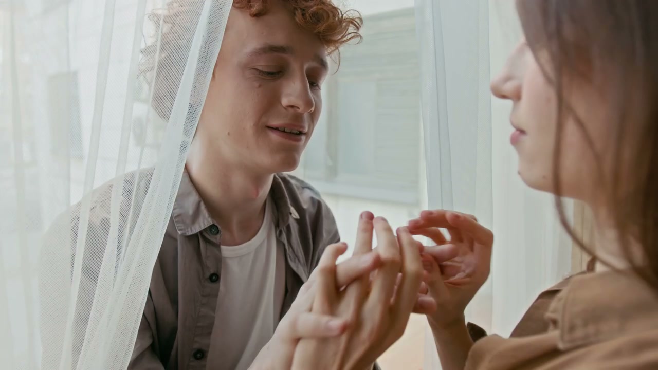 Romantic Couple Intertwining Hands Indoors
