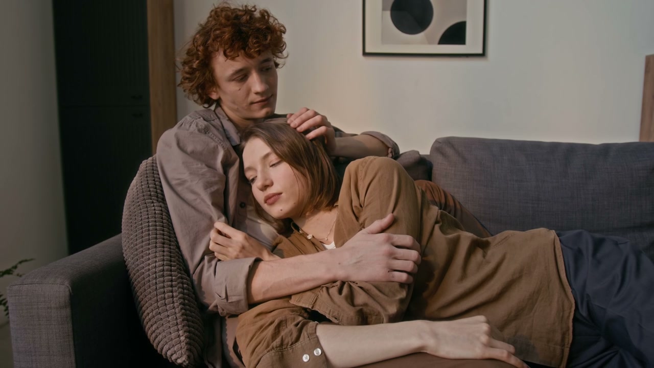 Romantic Couple Cuddling on Sofa at Home