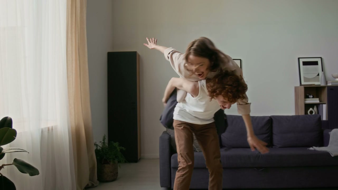 Playful Couple Piggyback Ride at Home