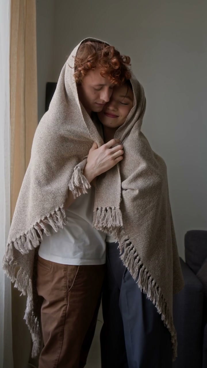 Romantic Couple Cuddling in Blanket at Home
