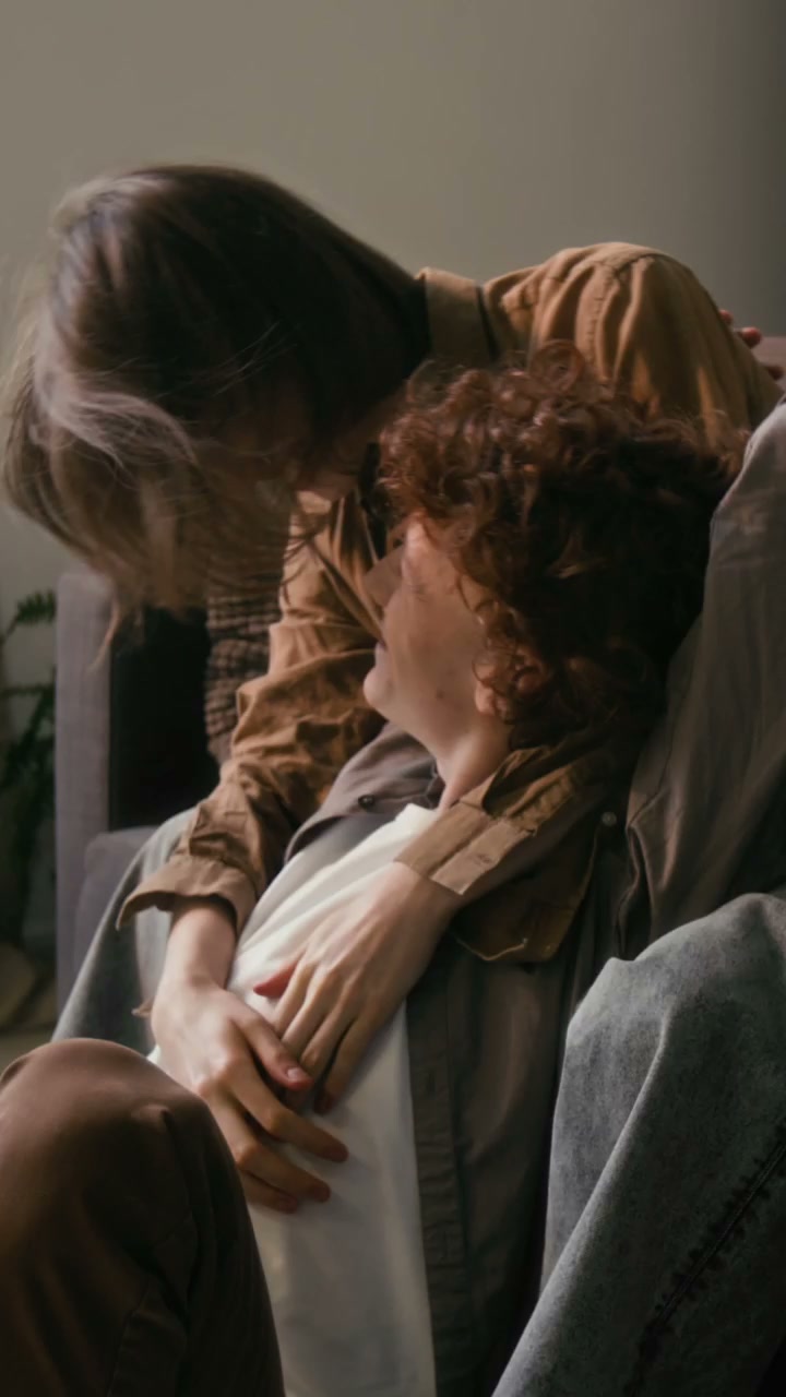 Couple Cuddling on Sofa at Home
