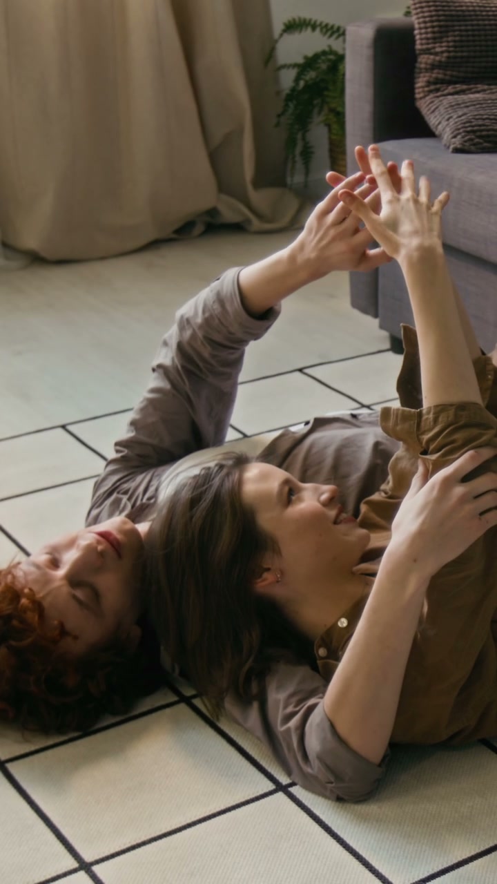 Couple Lying on Floor, Holding Hands