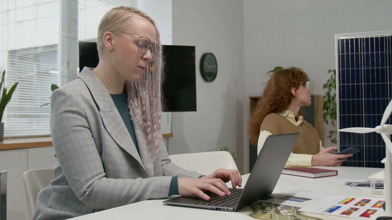 Woman Typing on Laptop in Renewable Energy Office