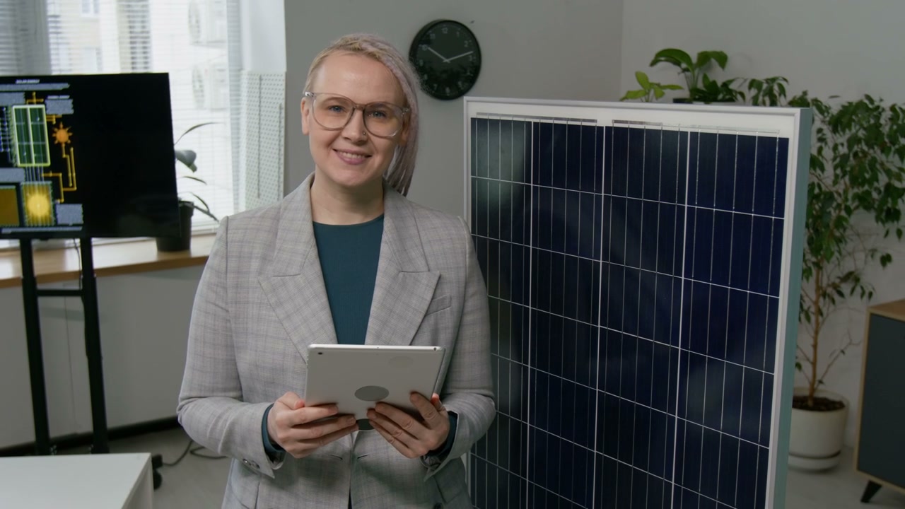 Smiling Woman with Solar Panel in Office