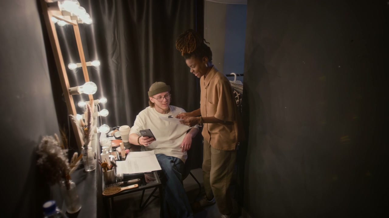 Comedian and Manager Discussing Script Backstage