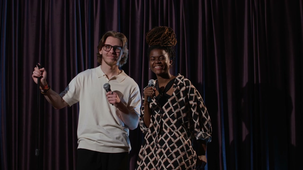 Comedians Posing with Microphones on Stage