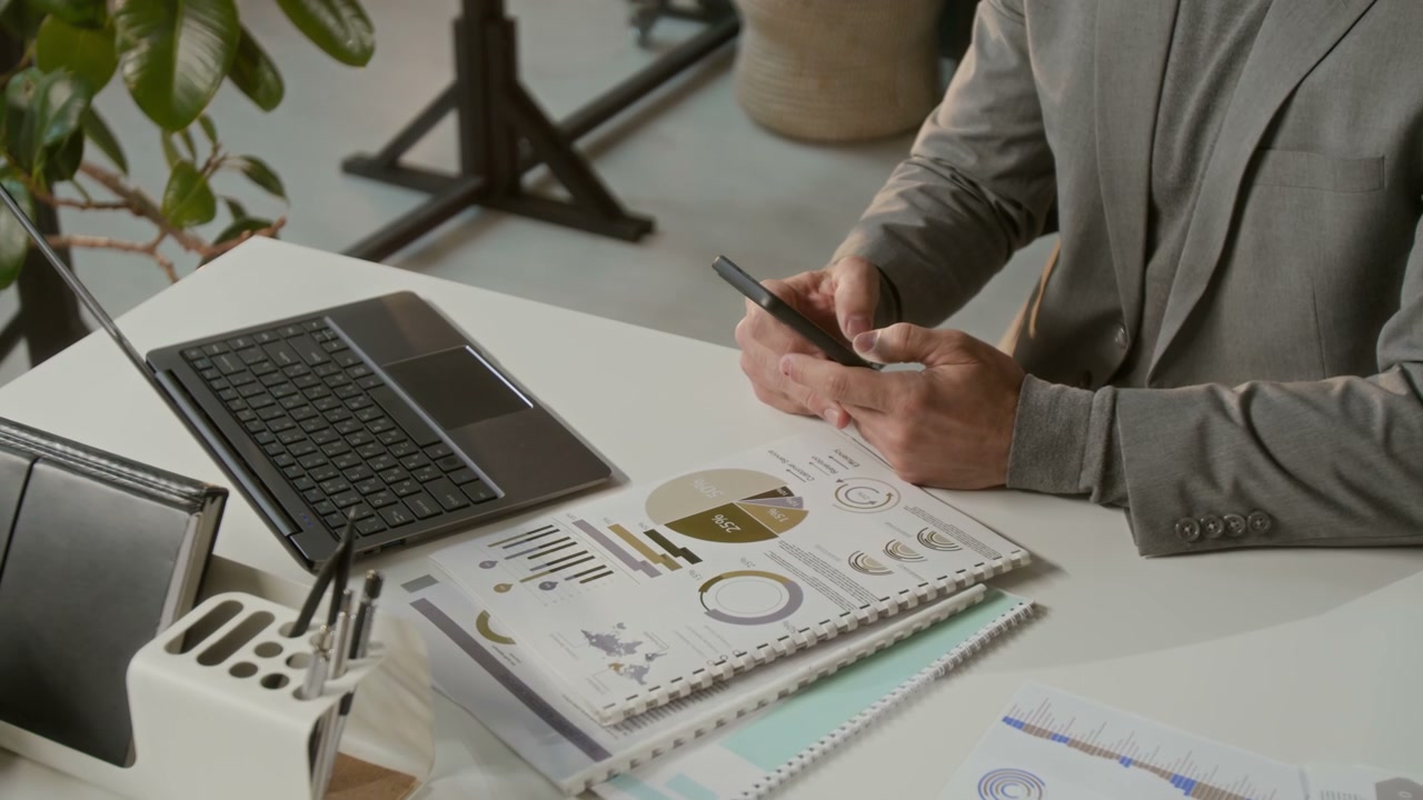 Businessman Using Smartphone at Desk