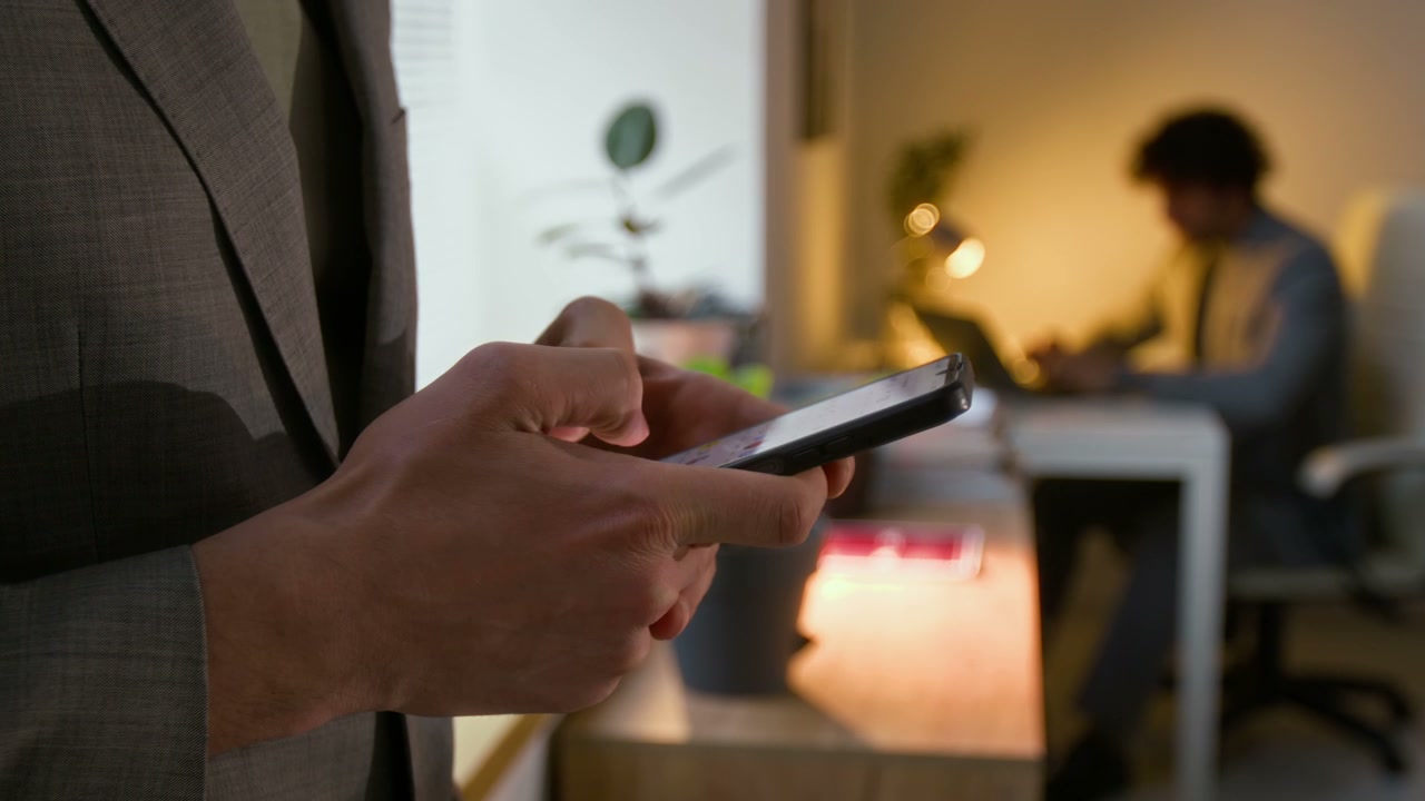 Business Person Using Smartphone in Office