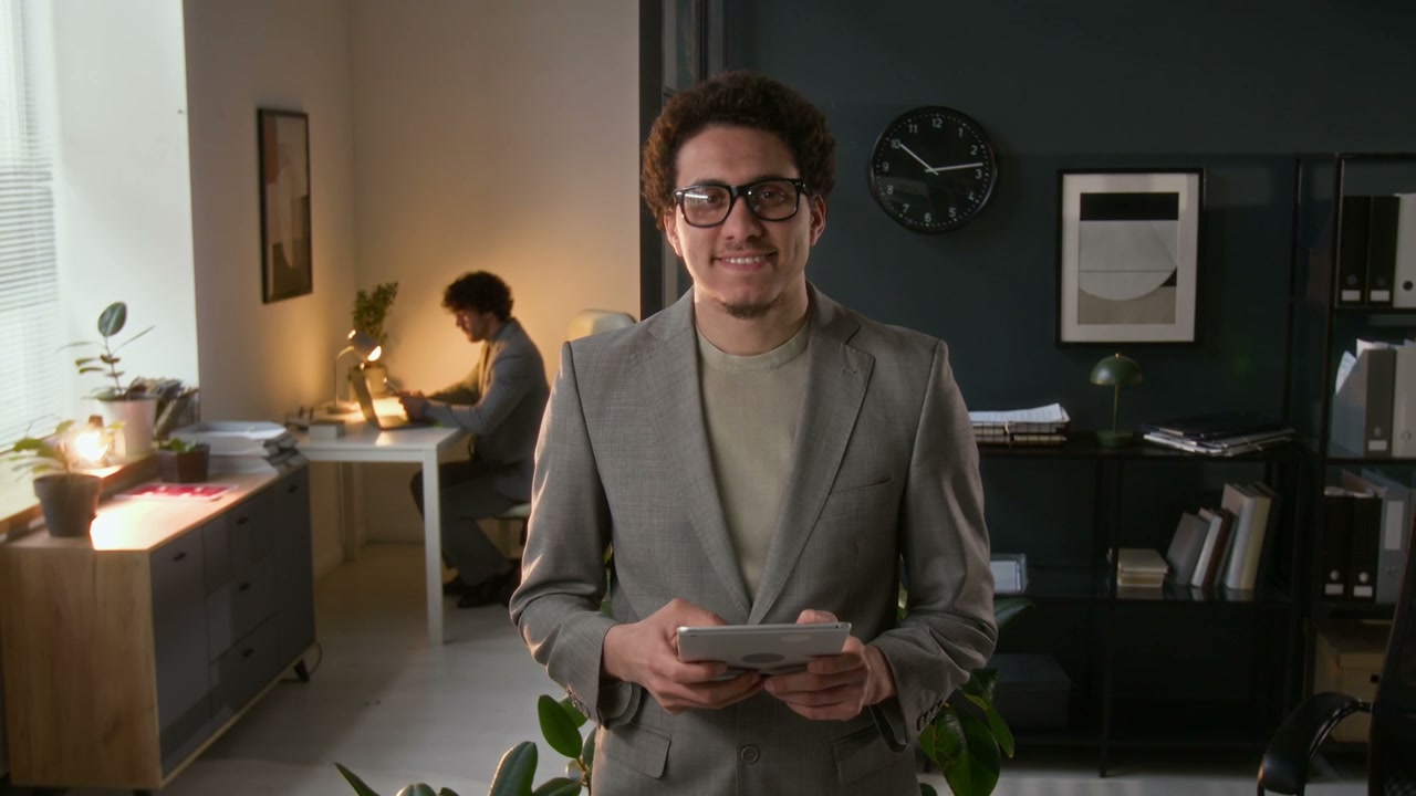 Smiling Young Businessman with Tablet in Office