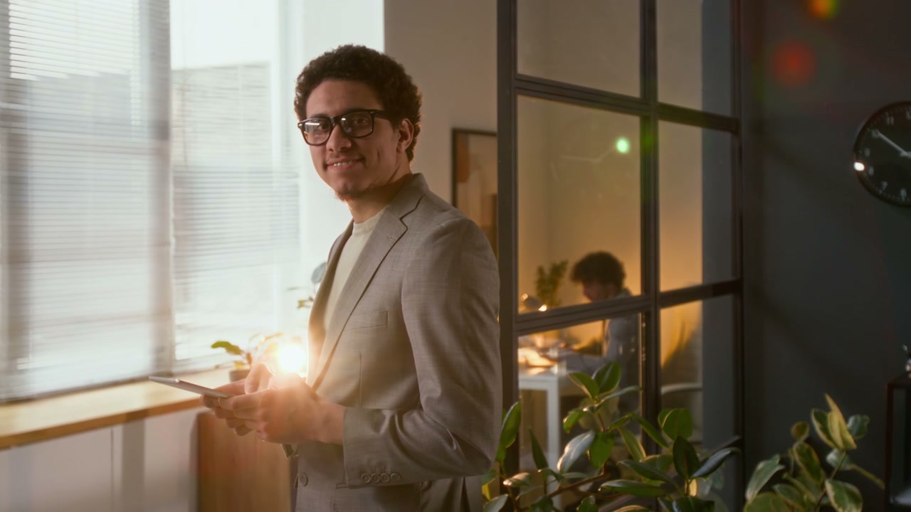 Young Businessman Smiling with Tablet in Office