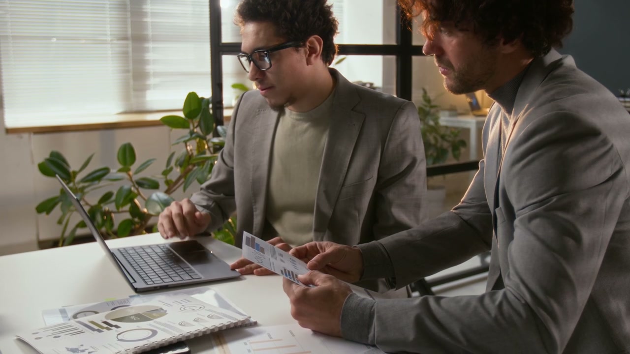 Businessmen Discussing Data in Office