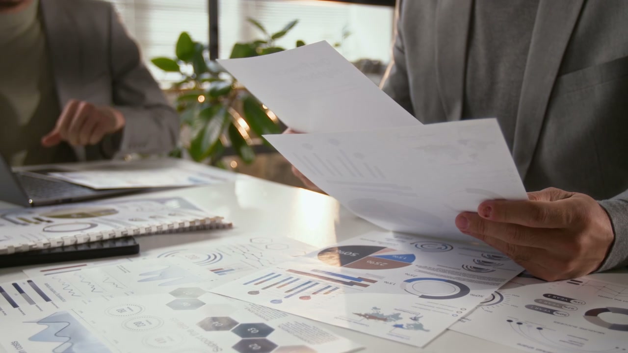 Business People Reviewing Charts and Documents