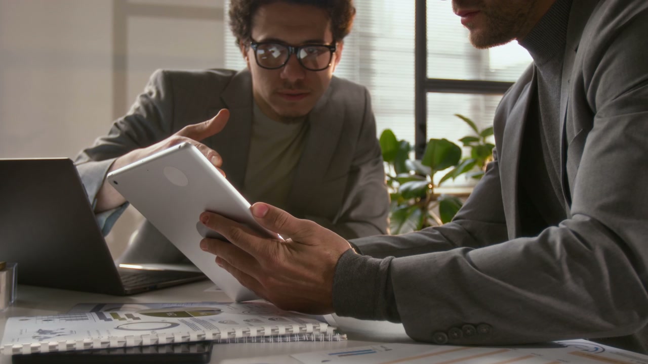 Business Colleagues Discussing Data on Tablet