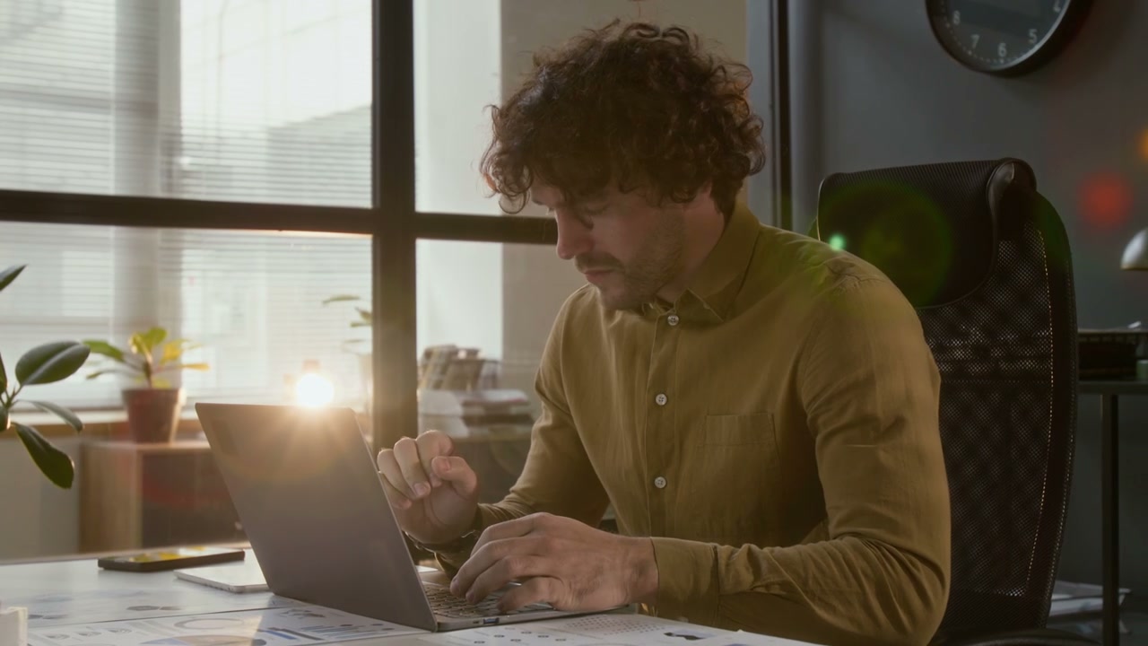 Professional Man Typing on Laptop in Office