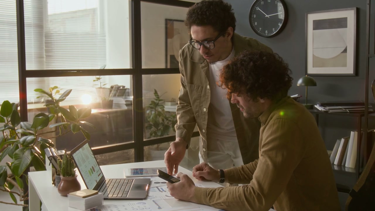 Businessmen Discussing Data in Office