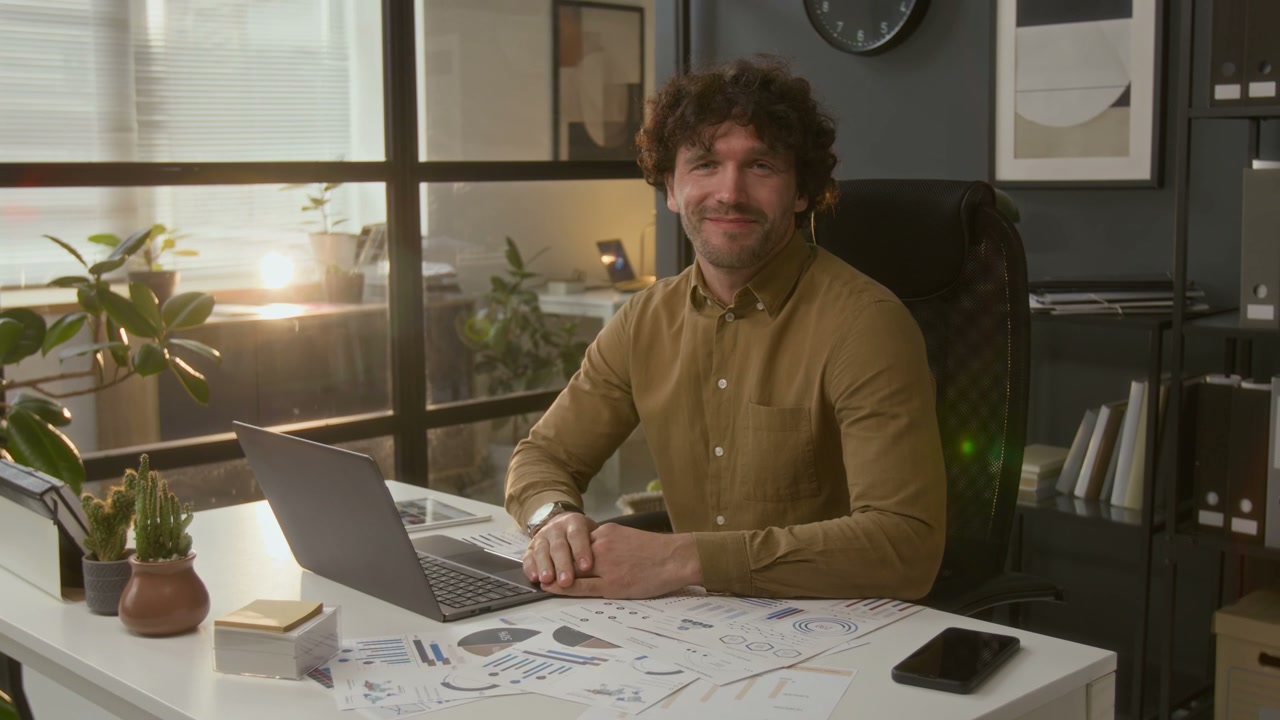Businessman Smiling at Camera in Office