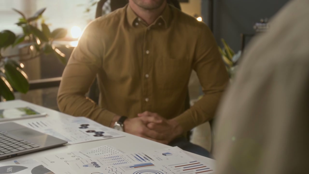 Business Partners Shaking Hands at Desk