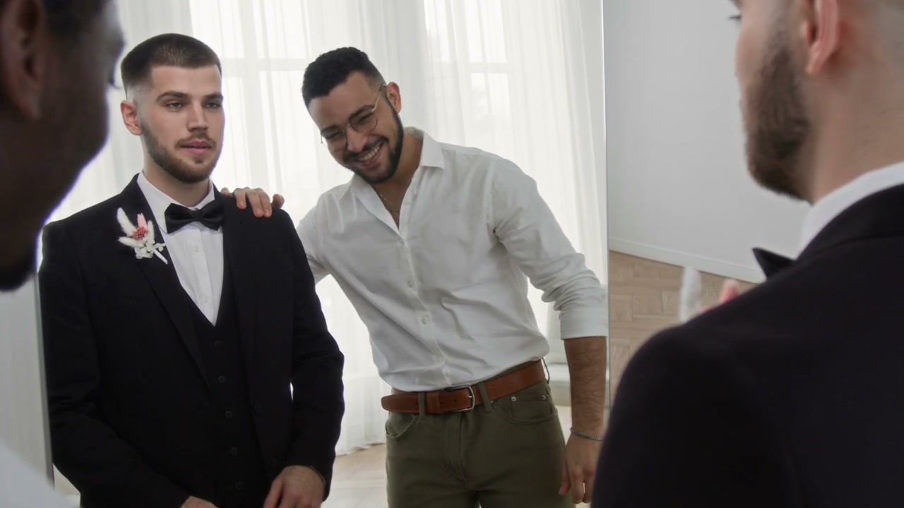Groomsmen Help Groom Adjust Wedding Suit