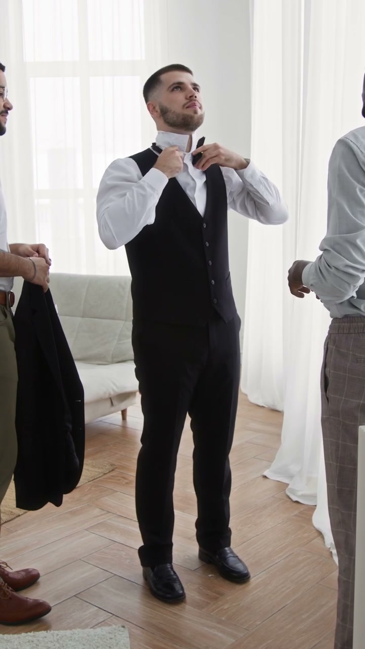 Groom Getting Help with Bow Tie on Wedding Day