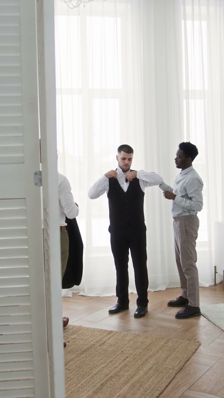 Friends Help Groom Dress on Wedding Day
