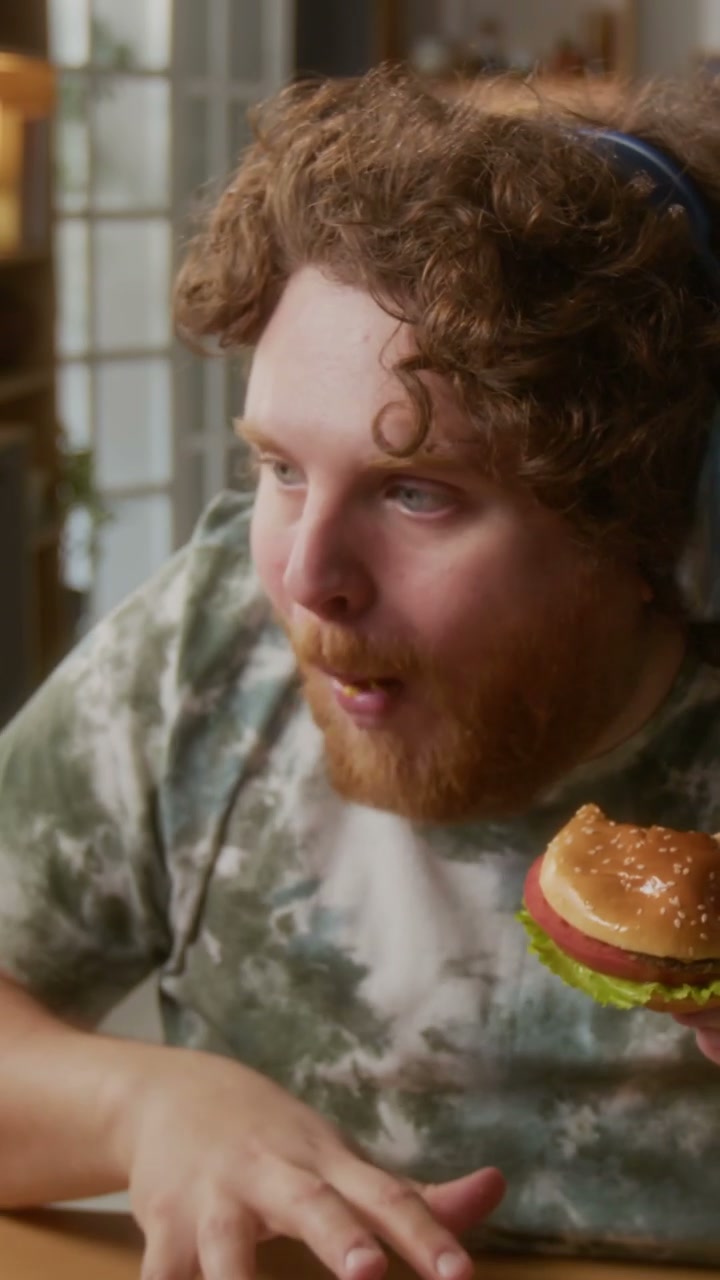 Man Eating Burger and Playing Video Game