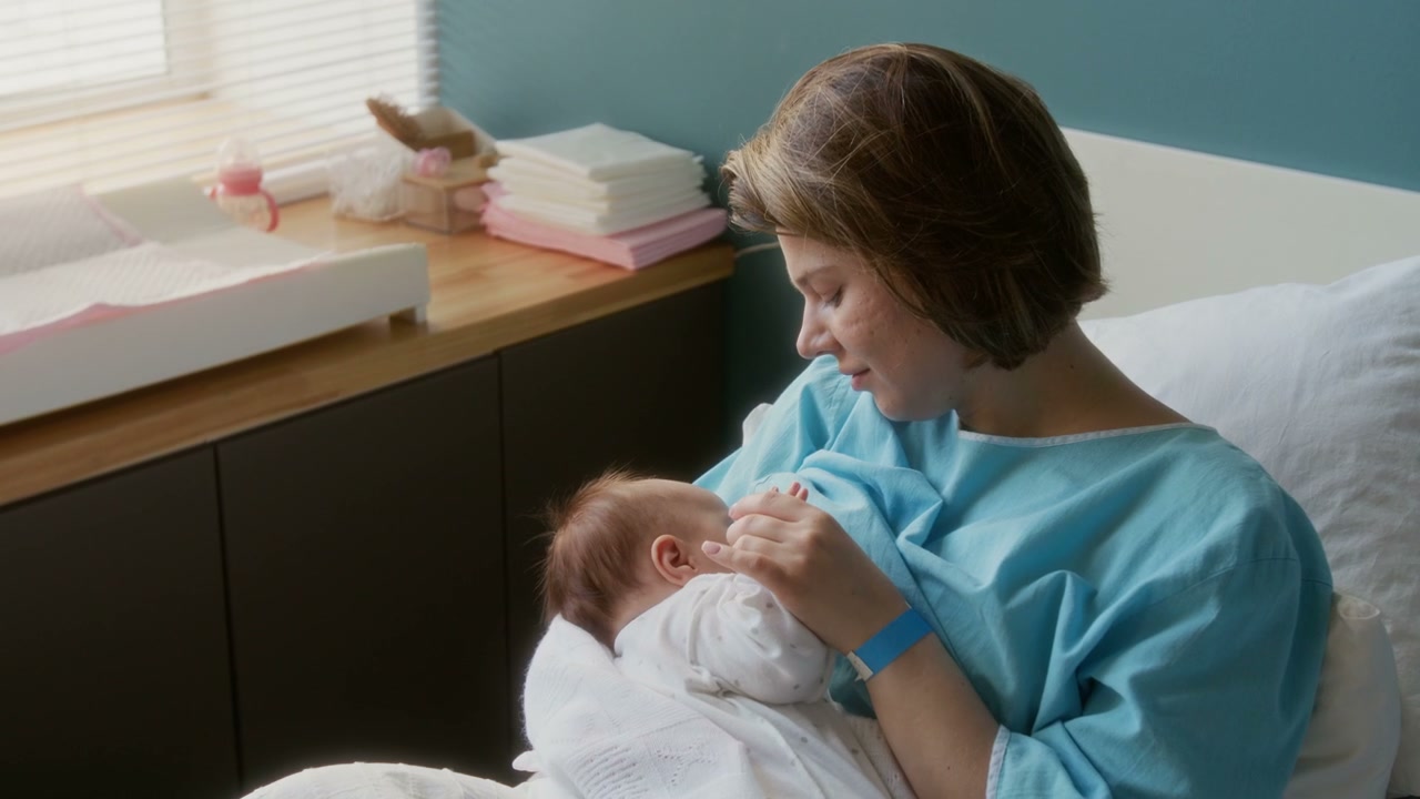 Mother Gently Caressing Newborn Baby in Hospital