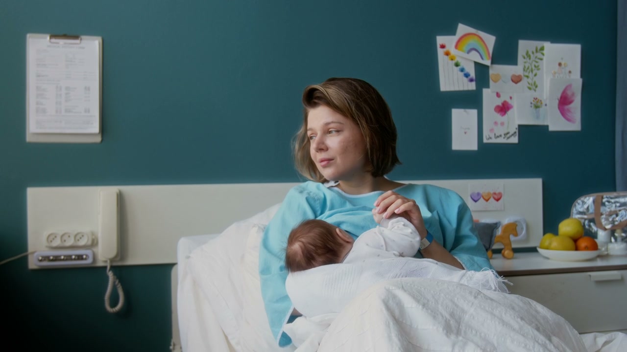 Mother Breastfeeding Newborn Baby in Hospital
