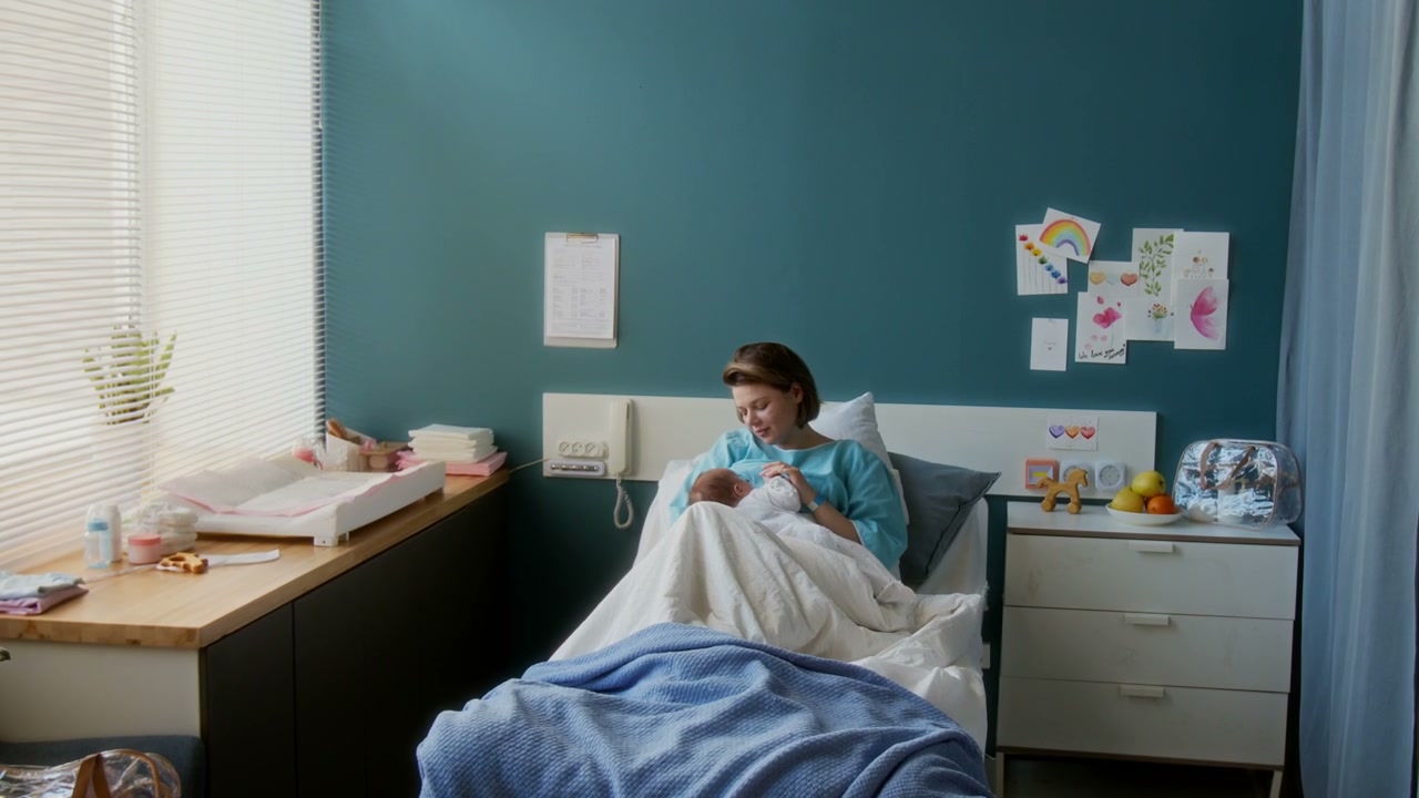 New Mother Cradling Newborn Baby in Hospital