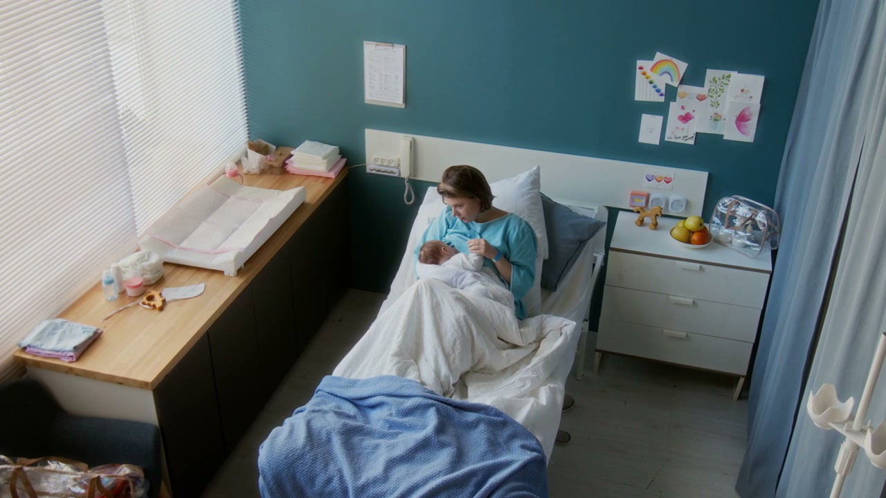 Mother Bottle-Feeding Newborn Baby in Hospital