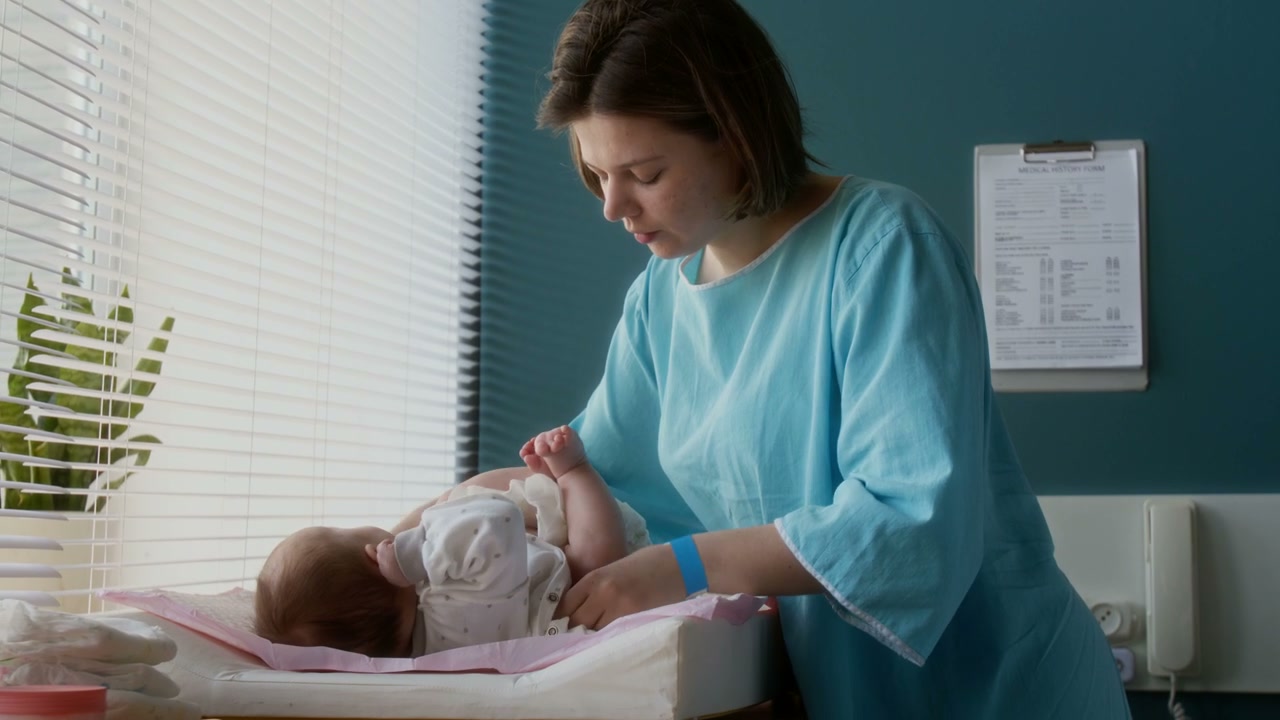 Mother Changing Baby's Diaper in Hospital