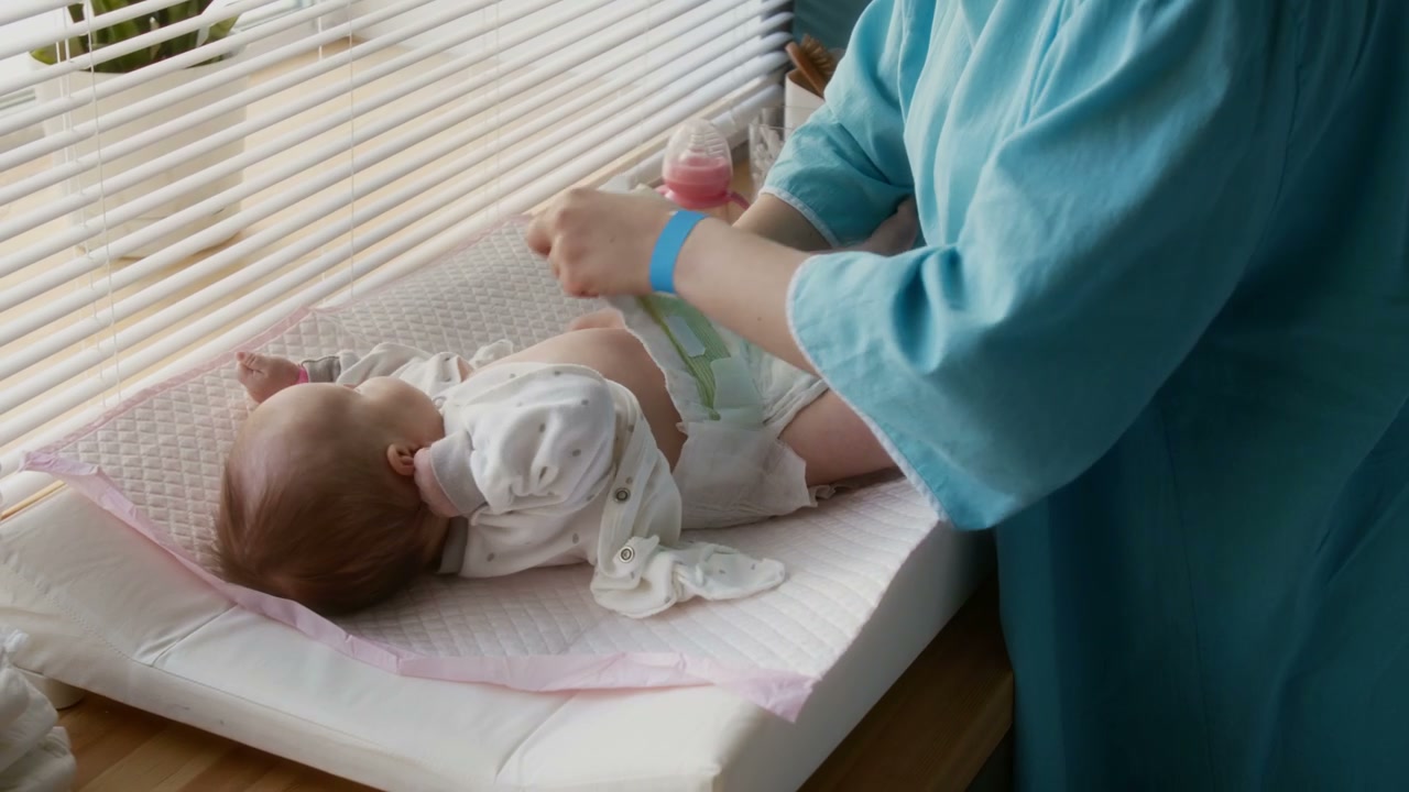 Parent Changing Newborn Diaper in Hospital