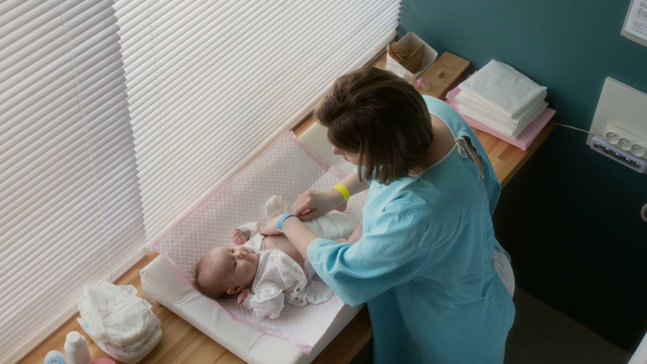 Mother Changes Newborn's Diaper in Hospital