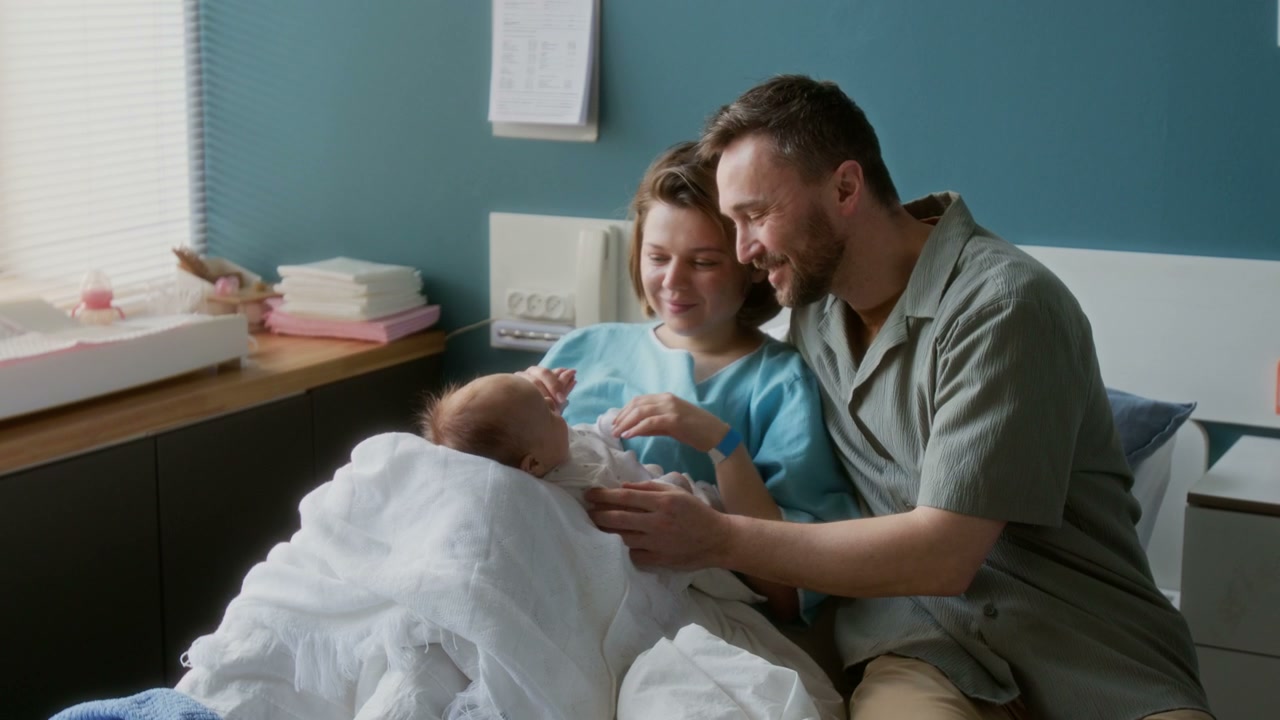 New Parents with Newborn Baby in Hospital Room