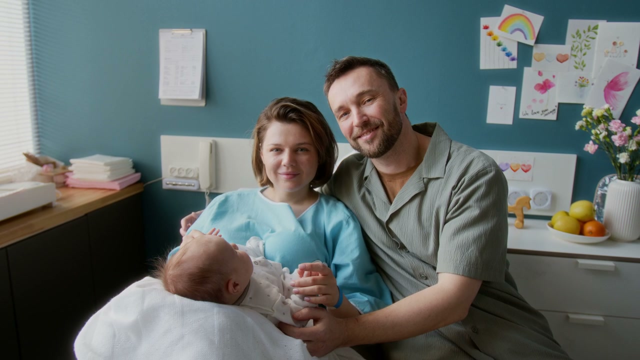 Happy Family With Newborn in Hospital Room