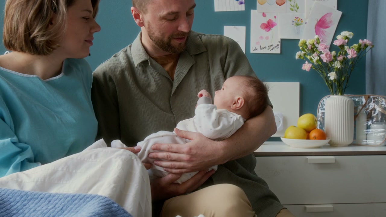 Parents Holding Newborn Baby in Hospital Room