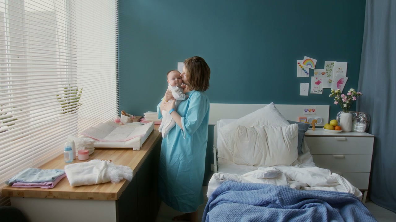 Mother Gently Rocking Newborn Baby in Hospital