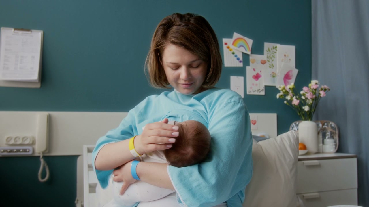 New Mother Bonding with Newborn Baby in Hospital