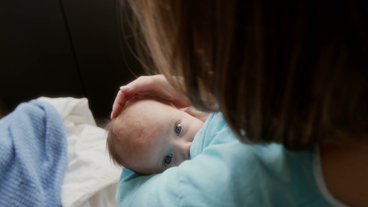 Mother Cradling Baby With Blue Eyes