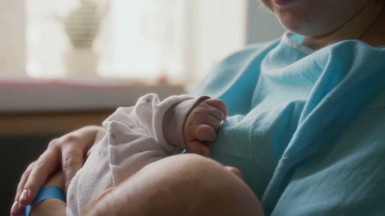 Mother and Newborn Baby Bonding Hands