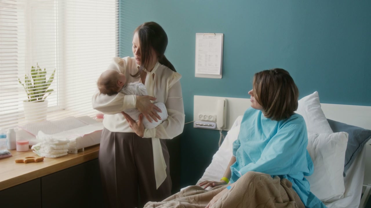Grandmother Holds Newborn in Hospital Room