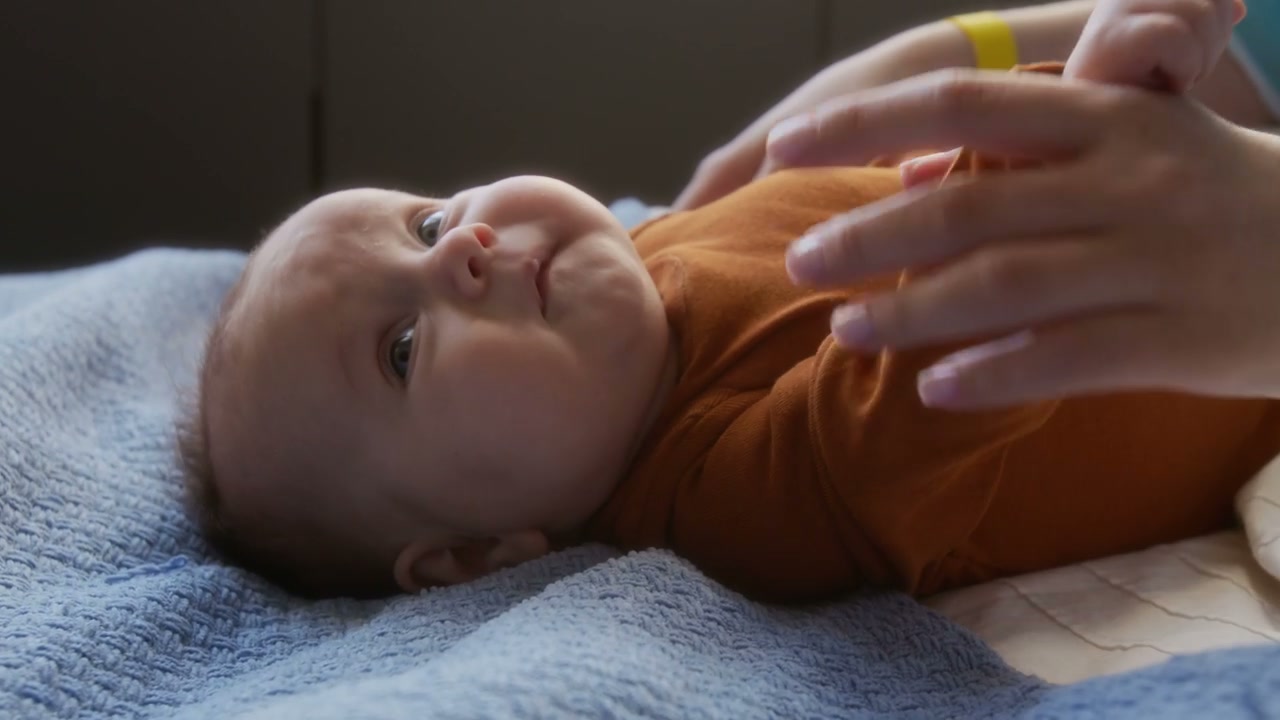 Parent Gently Playing with Newborn Baby