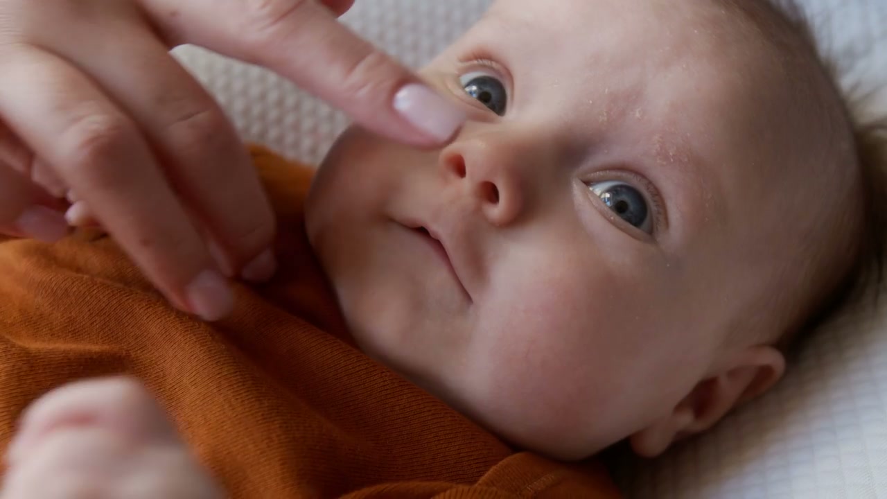Smiling Baby Reacting to Gentle Nose Poke
