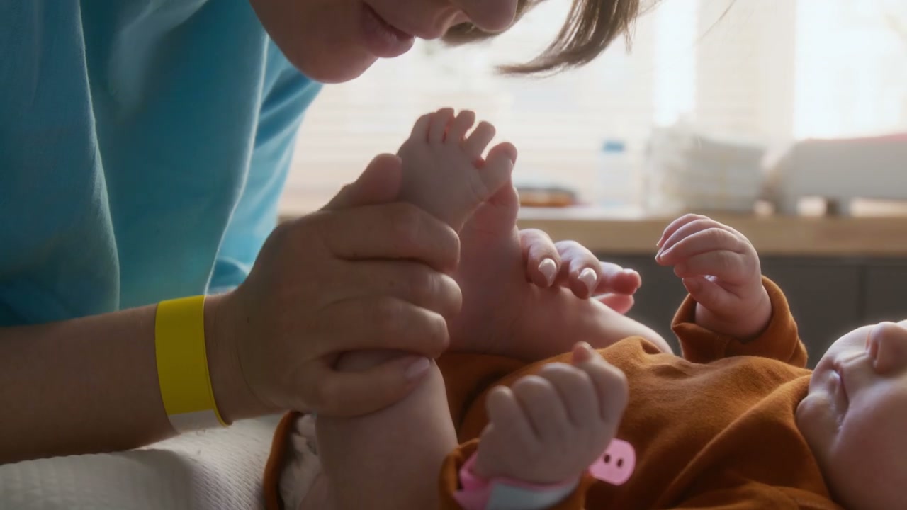 Mother Kisses Newborn Baby's Feet