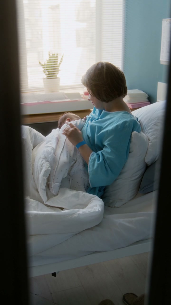 Mother Breastfeeding Newborn Baby in Hospital