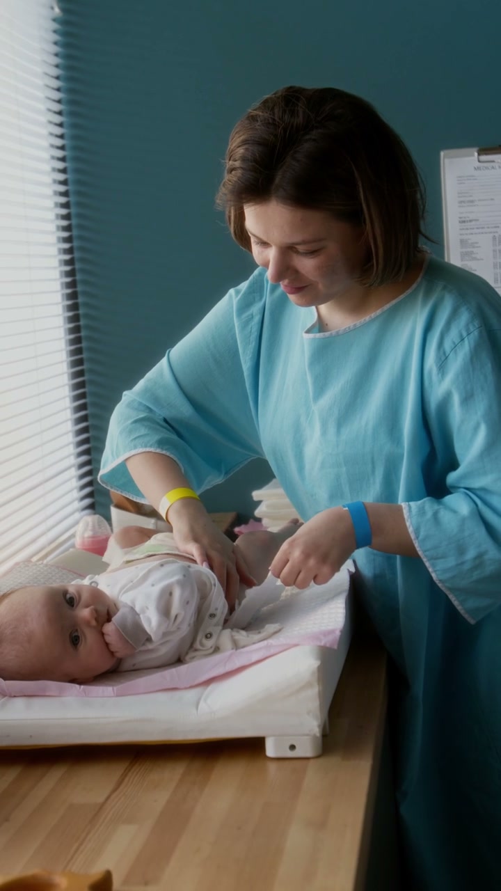 Mother Dressing Baby in Hospital