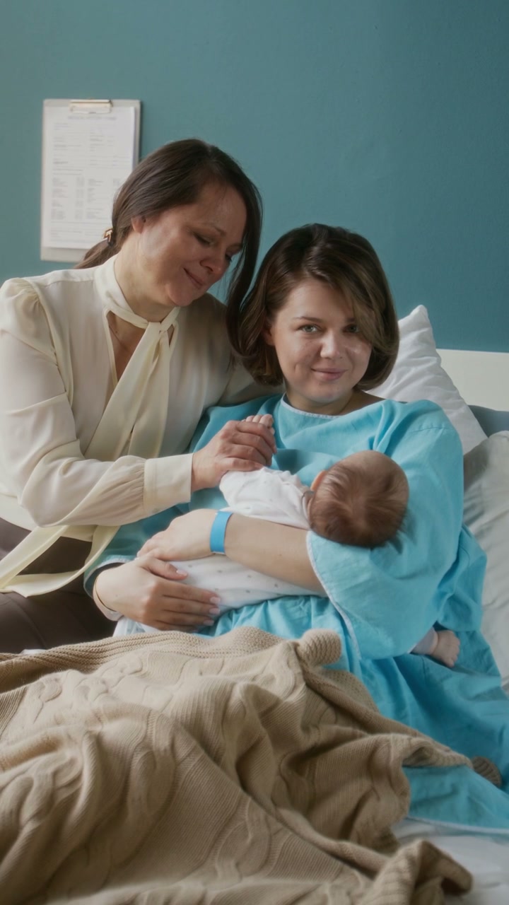 Mother and Grandmother Hold Newborn Baby