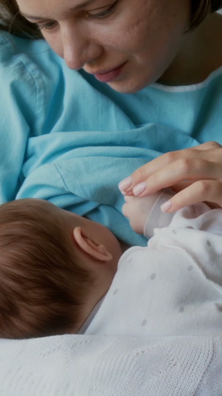 Mother Holding Newborn Baby's Hand