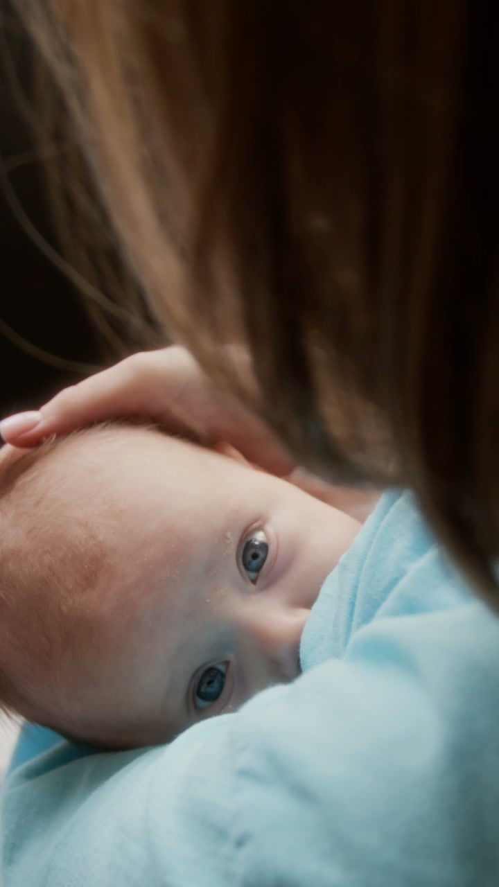 Newborn Baby Looking at Camera with Mother