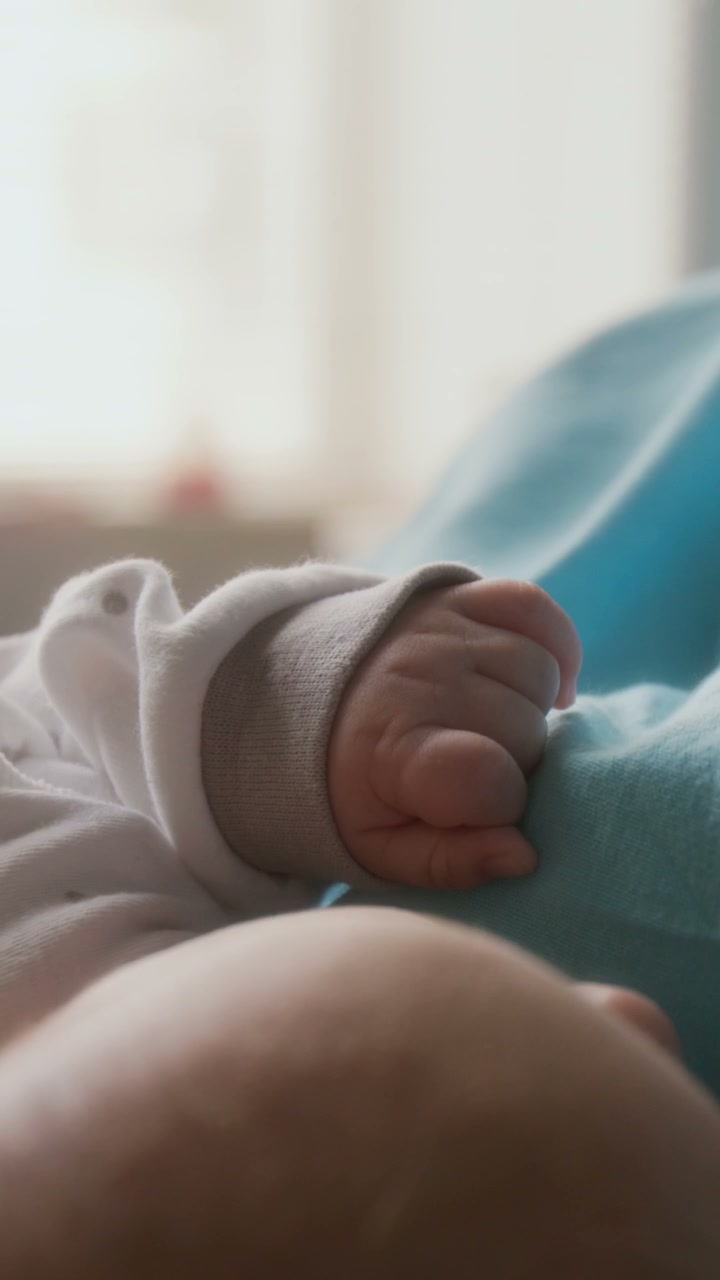 Newborn Baby's Hand Resting on Mother